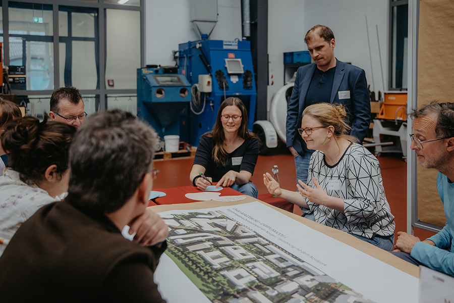 Studierende und Mitarbeitende der Uni Magdeburg tauschen sich an einem Tisch für die Gestaltung des Campus aus (c) Anna Friese Uni Magdeburg