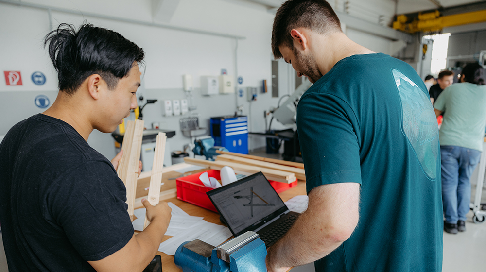 Zwei Studenten besprechen ihren Entwurf an einem Laptop in der StudierendenWerkstatt (c) Jana Dünnhaupt Uni Magdeburg